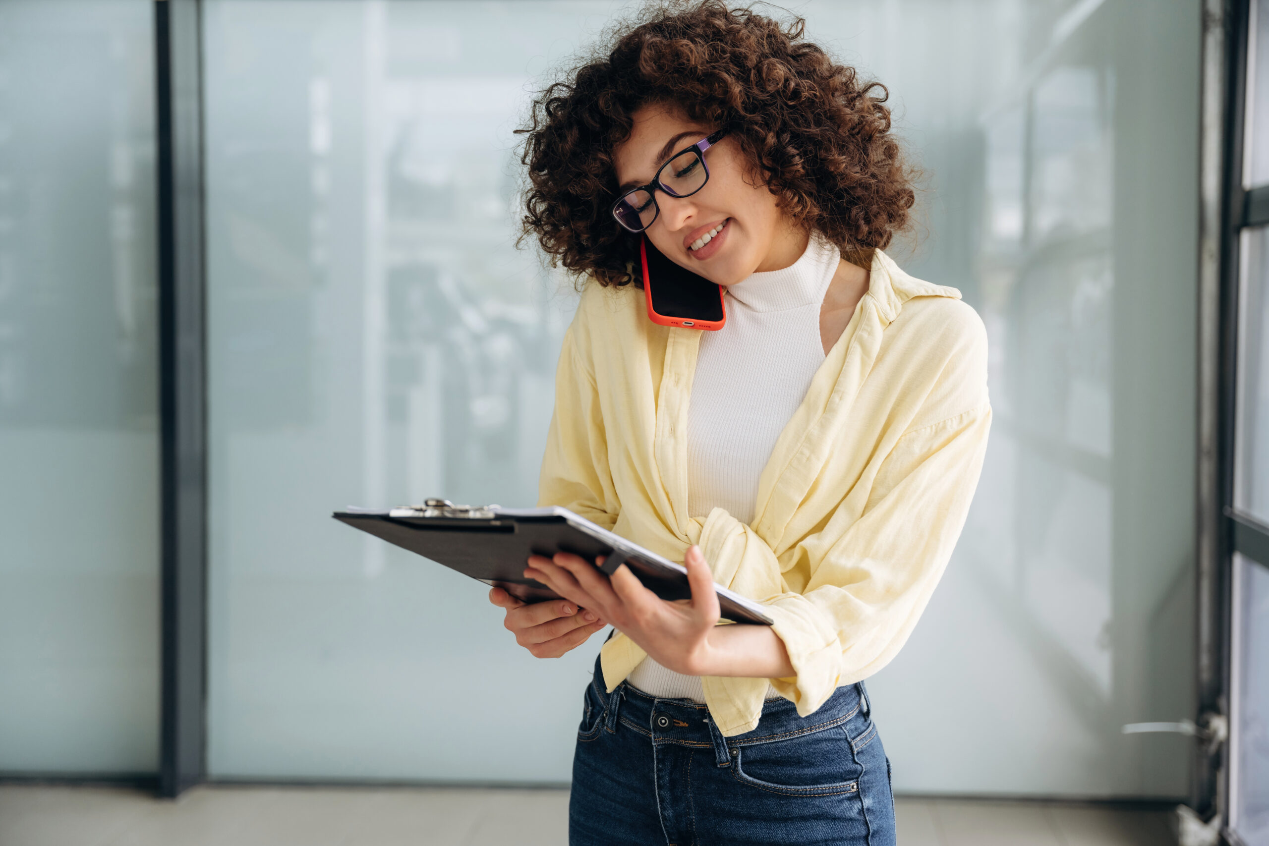 Woman with a clipboard talking on the phone