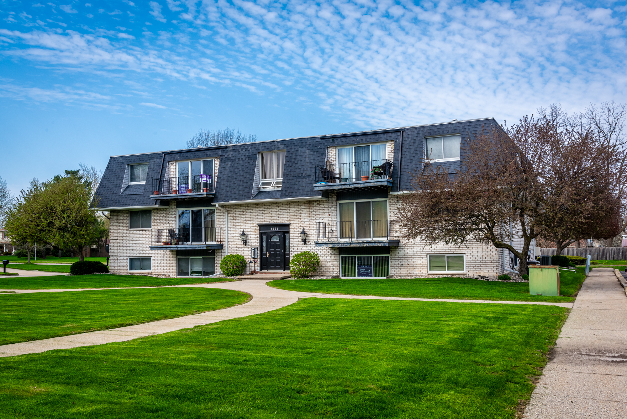 Front view with a green lawn and sidewalks